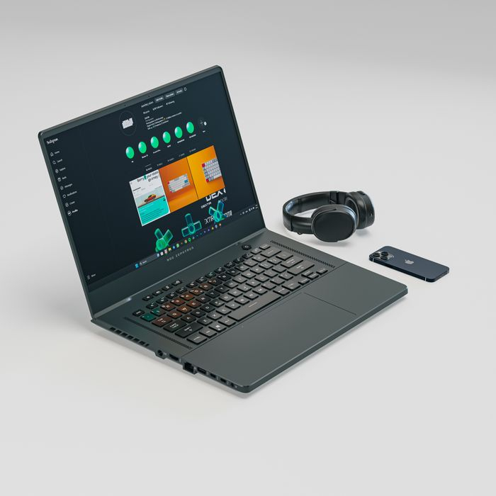 Minimalist tech setup featuring a laptop, smartphone, and headphones on a white background.